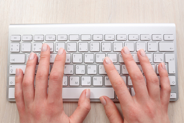 Female hands with keyboard on wooden desktop background - Foto, Imagen