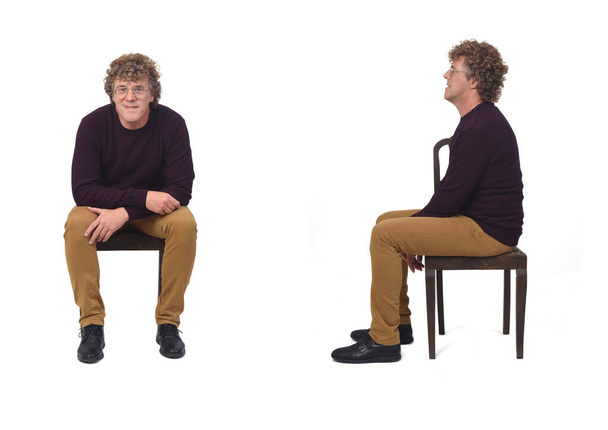 白い背景の椅子に座っている同じ男の正面図です - 写真・画像