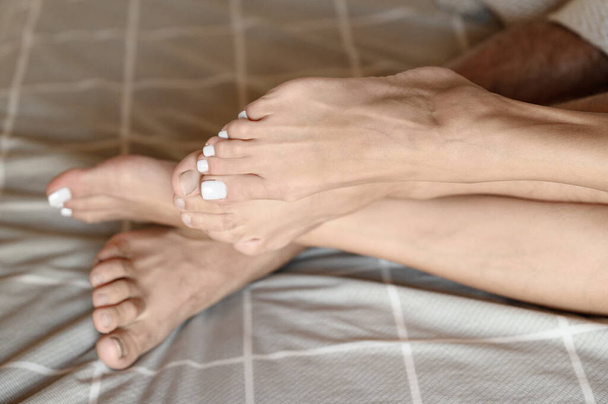 Δύο ζευγάρια πόδια ερωτευμένων από κοντά, πεντικιούρ στα νύχια των ποδιών.. - Φωτογραφία, εικόνα
