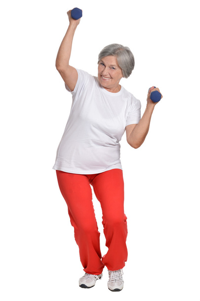 Senior woman exercising with dumbbells - Фото, изображение