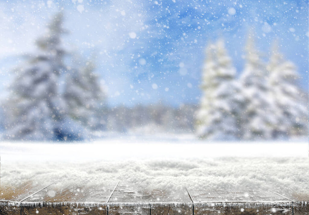 Xmas winter background. Winter snow landscape and rustic table of wood with snow on top. Christmas card. - Photo, Image