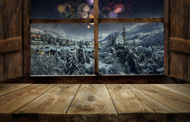 Wooden table and window with blurred christmas scene and fireworks at new year - Valokuva, kuva