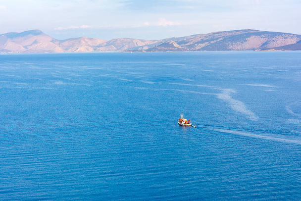 Um barco de pesca de madeira tradicional que flutua nas águas coloridas, Ermioni, Grécia. - Foto, Imagem