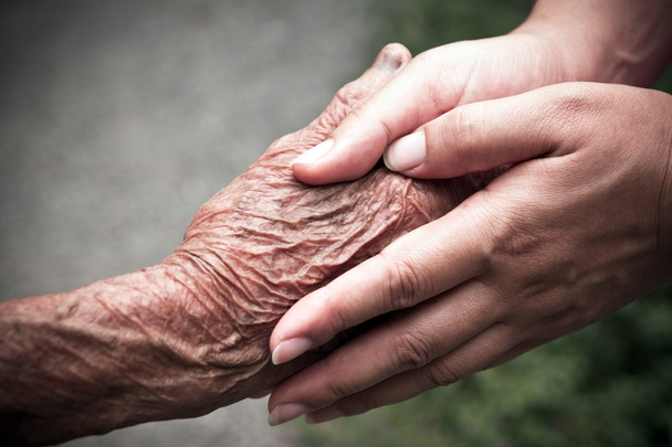 Senior and young holding hands - Foto, afbeelding