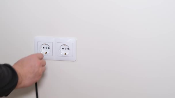 Connexion du cordon d'alimentation à une prise électrique. Une prise électrique portable classique dans le mur de la maison. Vidéo 4k - Séquence, vidéo