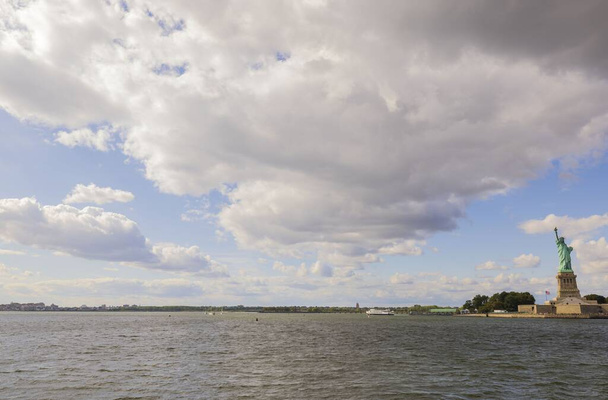 Krásný výhled na řeku Hudson a sochu svobody pod bílými mraky na pozadí modré oblohy. U.S.A - Fotografie, Obrázek