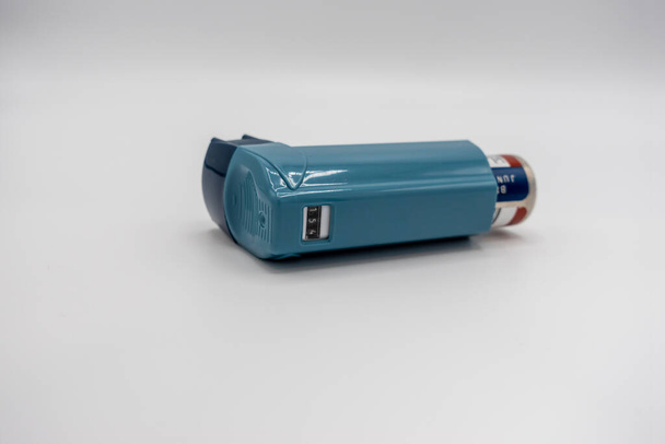Enfoque selectivo en un inhalador azul sobre un fondo blanco - Foto, Imagen