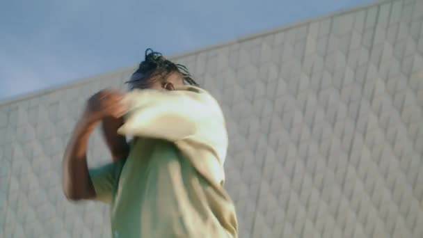 Πανέμορφος τύπος που χορεύει σε μοντέρνο κοντινό πλάνο τοίχου. Ευέλικτη αρσενική χορεύτρια μπαλέτου εκτελεί νέα χορογραφία σε εξωτερικούς χώρους. Αφροαμερικάνος που εκφράζει συναισθήματα μέσω της γλώσσας του σώματος στο δρόμο  - Πλάνα, βίντεο