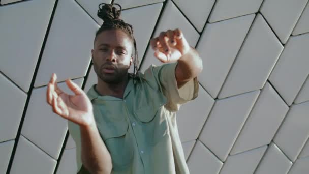 Charismatic performer dancing hands portrait. African american man showing contemporary choreography performance at wall background. Brown skin dreads dancer practicing freestyle at modern building  - Footage, Video