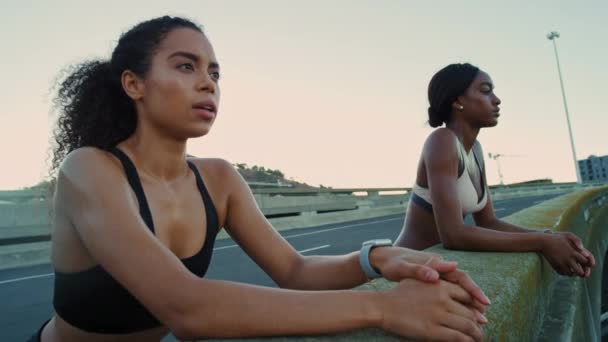 Black women, breathing or fitness break on city bridge, road or street in sunrise workout, training or exercise. Friends, runners or sports people resting after sunset marathon running for healthcare. - Footage, Video