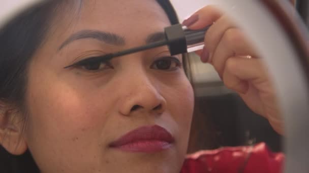 FECHAR-SE: Vista detalhada da bela mulher filipina aplicando rímel nas pestanas. Jovem senhora vestindo maquiagem para ocasião especial na frente de um espelho. Pessoa feminina cuidando de sua aparência. - Filmagem, Vídeo