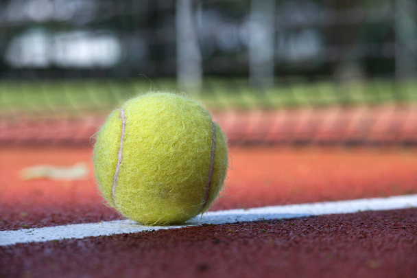 Tennis scene with white line and ball on hard court surface in low angle view - Photo, Image