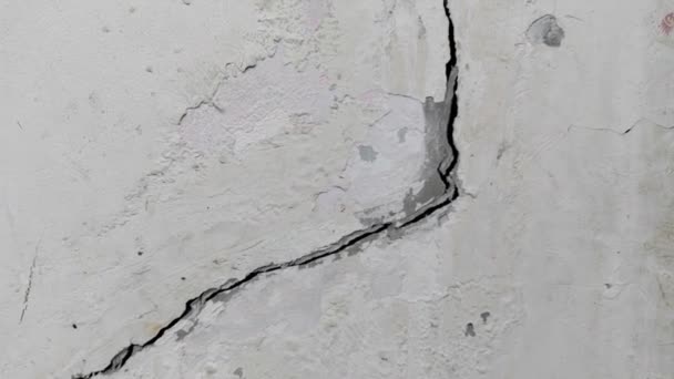 Sol en béton fissuré brisé à un vieux mur suite à une mauvaise construction ou un tremblement de terre - Séquence, vidéo