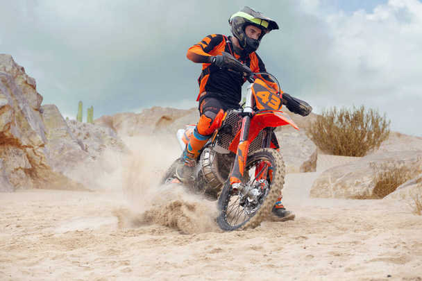 Young man practice riding dirt motorcycle. Splashing sand - Photo, Image
