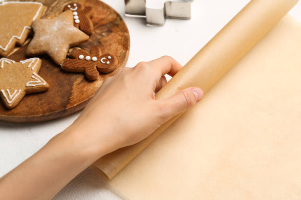Mains féminines avec papier cuisson et différentes emporte-pièces sur fond clair, gros plan - Photo, image