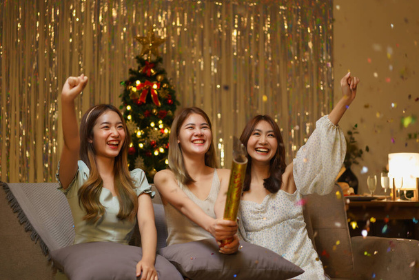 Konzept der Neujahrsfeier: Junge schöne Gruppe schießt Konfetti-Feuerwerk mit Spaß. - Foto, Bild