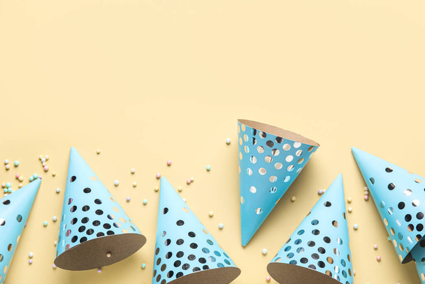 Party hats and confetti on yellow background - Photo, Image