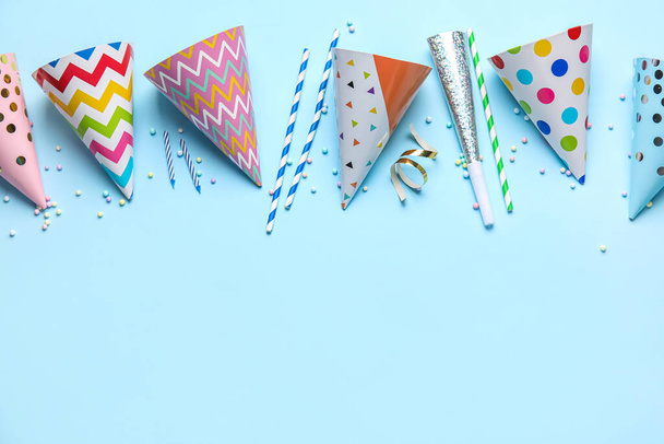 Party hats, confetti, straws and candles on blue background - Photo, Image