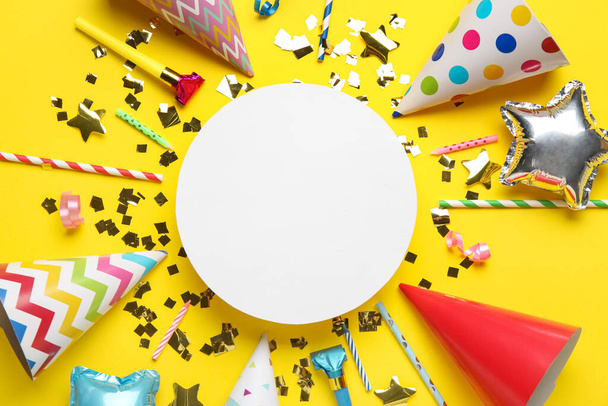 Blank card with party hats, confetti, straws and whistles on yellow background - Photo, Image