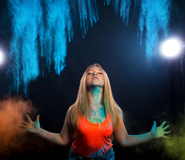 girl with colored powder exploding around her and into the background. - Foto, imagen