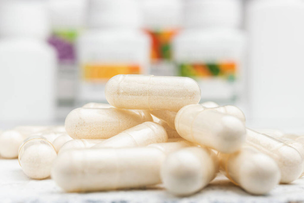 Капсулы с белыми лекарствами, витамины или лекарства, лечение лекарствами, концепция здравоохранения. - Фото, изображение