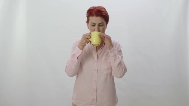 Karakter portré egy fiatal nő iszik egy csésze kávét, fekete vagy zöld tea. Fiatal egészséges tea vagy kávé nő szaglása, ivás és mosolygás elszigetelt fehér háttér. - Felvétel, videó