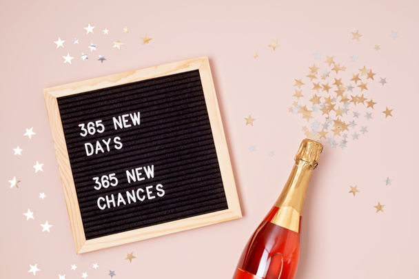 365 neue Tage, 365 neue Chancen. Papptafel mit Motivationszitat auf rosa Hintergrund. Neujahrsvorsätze und Zielsetzung, Selbstverbesserung und Entwicklungskonzept - Foto, Bild