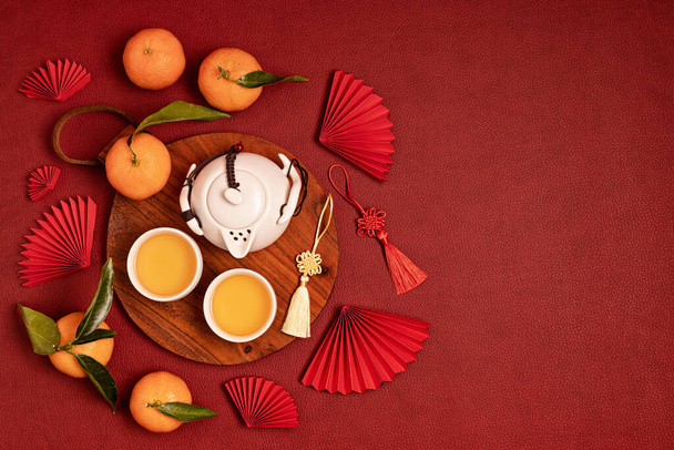 中国の旧正月の祭りの装飾。伝統的な旧正月のフラット緑茶、赤い紙のファン、みかんとレイアウトします。トップ表示 - 写真・画像