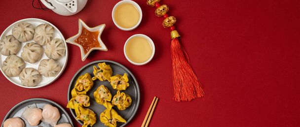 Kínai újév fesztivál asztal felett piros háttér. Hagyományos holdújévi étel. Lapos fekvés, csúcskilátás. Zászlós - Fotó, kép