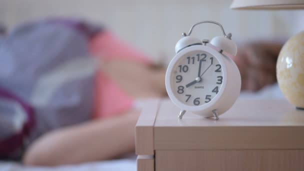 Alarm clock calls 8 am, a woman wakes up and gets out of bed - Felvétel, videó