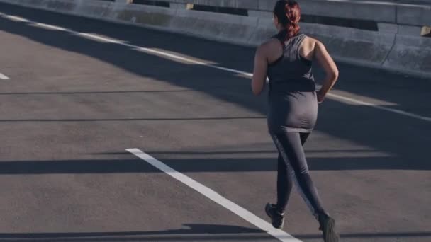 Woman, running or city fitness in weightloss goals, fat management or healthcare wellness in slow motion workout, training or road exercise. Runner, sports athlete or normal person in street marathon. - Footage, Video