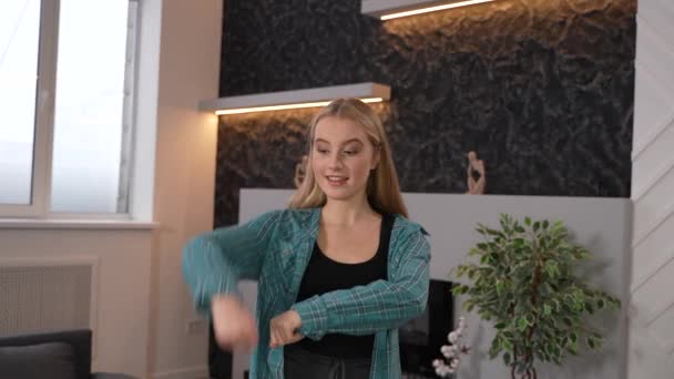 Młoda, piękna nastolatka tańcząca taniec nowoczesny w domu. Atrakcyjna dziewczyna poruszająca się rytmicznie w rytm muzyki tworzącej treści dla mediów społecznościowych przed kamerą. Materiał wysokiej jakości - Materiał filmowy, wideo