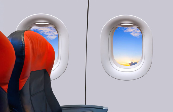 Окна и кожаные сиденья внутри самолета во время полета на восходе солнца в утреннее время, вид изнутри с копировальным пространством - Фото, изображение
