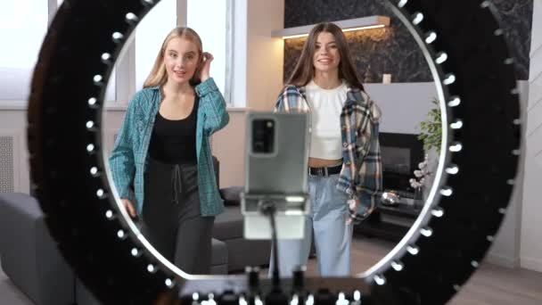 Deux filles souriantes qui créent du contenu pour les médias sociaux. Les adolescents dansent hip hop devant une caméra smartphone et une lampe annulaire. Images de haute qualité - Séquence, vidéo