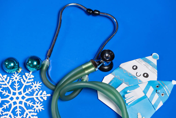 Christmas and New Year Medicine - Stethoscope, Snowmen and Snowflakes on a Blue Background, Top View. - Фото, зображення