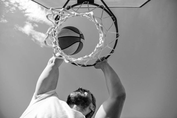 jugador de baloncesto lanza la pelota en el aro al aire libre, apuntando. - Foto, Imagen