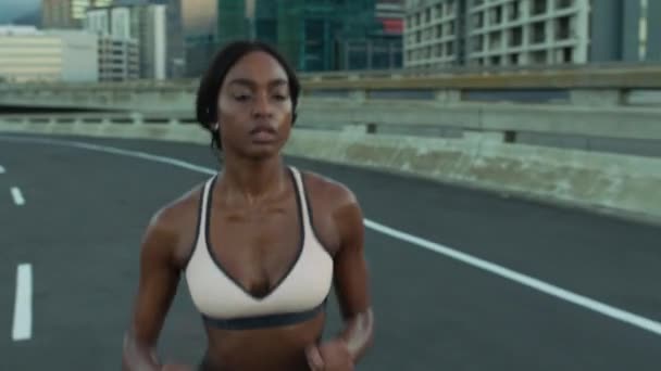 Runner, fitness or black woman running on road, street or asphalt training for a marathon or triathlon in a city. Wellness, girl or healthy sports athlete in a cardio exercise or workout in Detroit. - Footage, Video