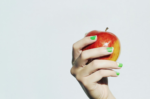 Apple in hand with manicure.beauty salon woman.nail design - Photo, Image