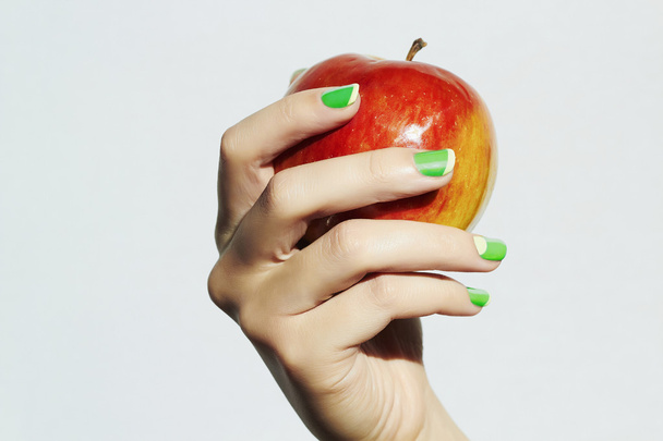 Apple in hand with manicure.beauty salon woman.nail design - Фото, изображение