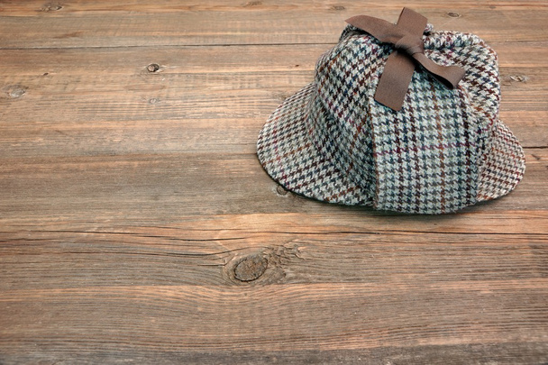 Deerstalker of Sherlock hoed op houten tafel - Foto, afbeelding