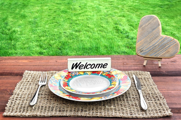 Tavolo da picnic con cuore in legno e segno di benvenuto
 - Foto, immagini