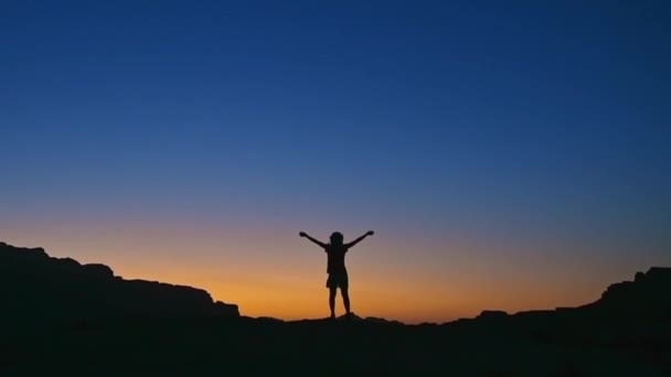 Boldog ünneplés győztes siker nő naplementekor vagy napkeltekor állva felemelt karokkal ünnepli, hogy elérte a hegycsúcs cél során túrázás utazás túra - Felvétel, videó