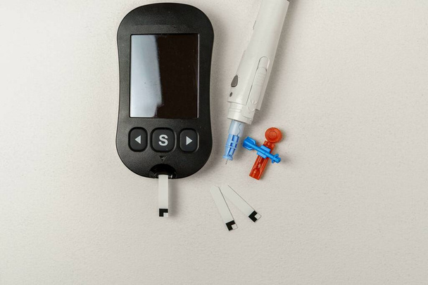 Zestaw do leczenia cukrzycy z cyfrowym miernikiem poziomu glukozy we krwi, lancety, urządzenie do lancowania na białym tle - Zdjęcie, obraz