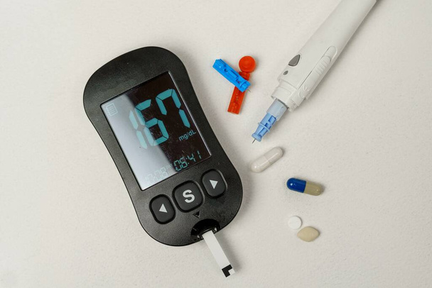 Cukorbetegség kezelésére szolgáló készlet digitális vércukorszint mérő, lándzsák, lándzsa eszköz fehér alapon - Fotó, kép