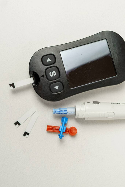 Diabetes léčba kit s digitální krevní glukózy metr, kopí, kopí zařízení na bílém pozadí - Fotografie, Obrázek