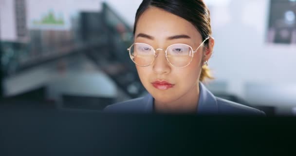 Visage, lunettes et gestion avec une femme asiatique d'affaires au travail sur un ordinateur dans son bureau. Données, lecture et courrier électronique avec une jeune employée travaillant sur un rapport utilisant un ordinateur de bureau pour la recherche. - Séquence, vidéo
