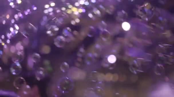 Muchas burbujas de jabón están volando en el aire por encima de las cabezas de las personas que bailan en la fiesta - Metraje, vídeo