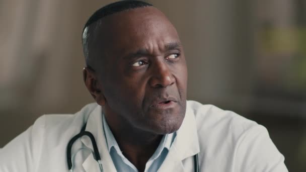 Озадаченный вдумчивый старший мужчина профессиональный медик зрелый взрослый доктор африканский американский мужчина в медицинском пальто идея планирования мозговой штурм мысли, размышляющие о здравоохранении и медицине концепции - Кадры, видео