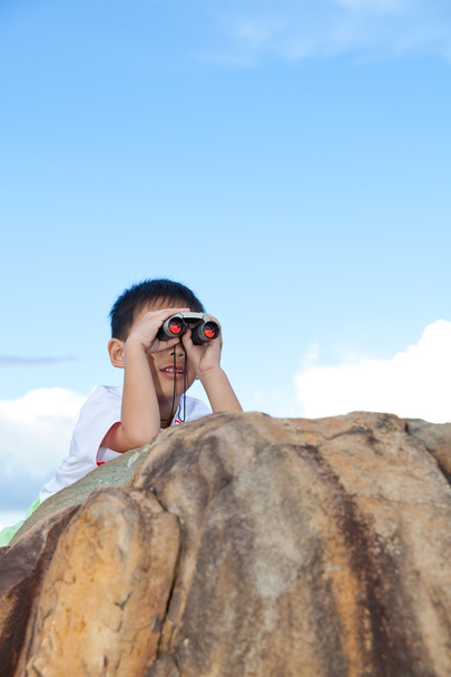 Feliz niño explorando al aire libre trepando en una roca con te
 - Foto, imagen