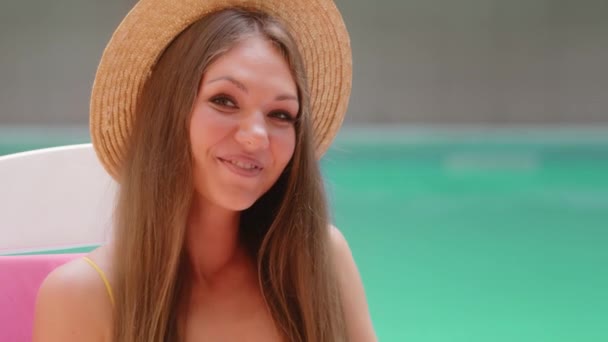 Portrait Fille blonde européenne belle caucasienne sympathique femme touriste se reposant près de la piscine d'été en regardant la caméra faisant geste main coeur amour romantique symbole profiter vacances voyage harmonie concept - Séquence, vidéo